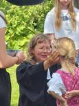 Pfarrerin Kurlberg segnet ein Mädchen mit Dirndl und Zopf