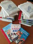 Bücherstapel aus Kinderbibeln mit Geschenktaschen