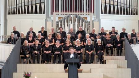 Pfarrerin Therese Wagner spricht am Pult in der Kirche. Im Hintergrund Orgel mit Chor.